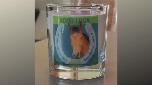 a personalised scented candle featuring a horses head inside a horseshoe with good luck written above