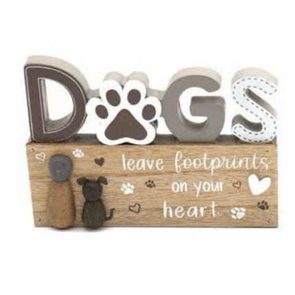 A wooden sign with 3D letters spelling DOGS, where the O is a paw print. Below, it reads: leave footprints on your heart, with small dog and paw print decorations.