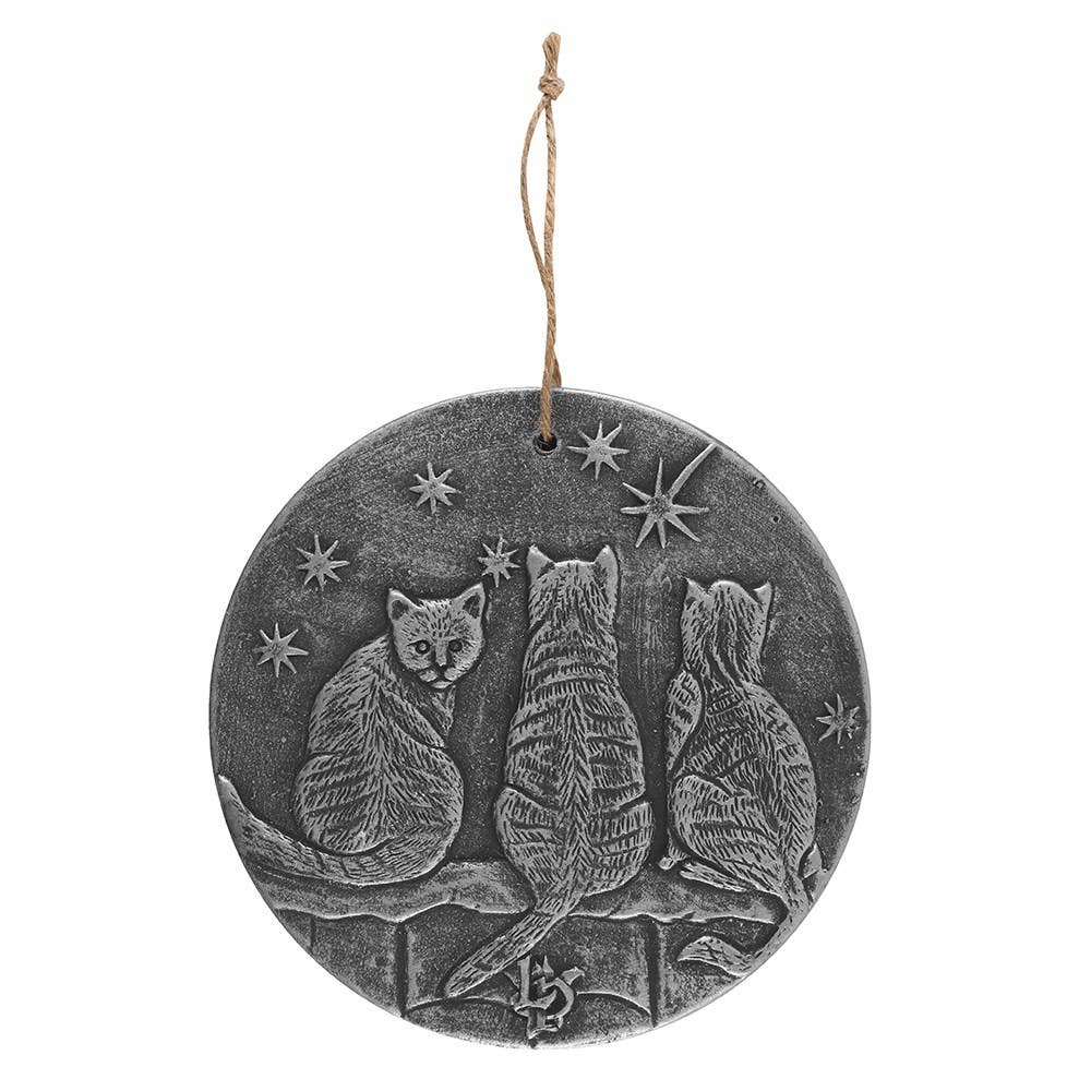 a silver coloured plaque with three cats on a fence star gazing