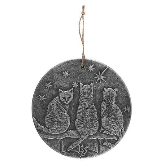a silver coloured plaque with three cats on a fence star gazing