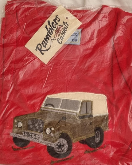 The Ramblers Embroidered T Shirt Farm Vehicle Childrens is a red tee, new in packaging, featuring a green vintage farm vehicleâ€”a perfect addition to any kidâ€™s wardrobe.