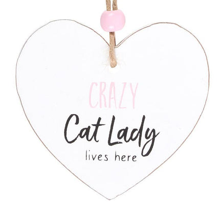 close up of a heart shaped sign which reads crazy cat lady lives here, suspended by a piece of twine and finished with a wooden bead