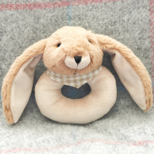 a round cream baby rattle with a cute brown floppy eared bunny head