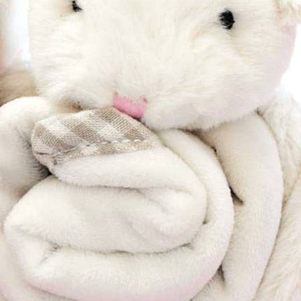a close up view of a cream fluffy bunny with a soft blanket comforter wrapped up in his arms