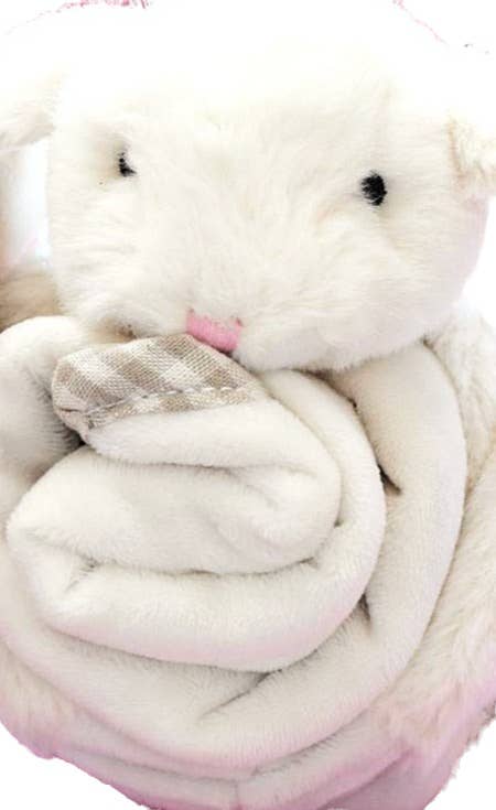 a close up view of a cream fluffy bunny with a soft blanket comforter wrapped up in his arms