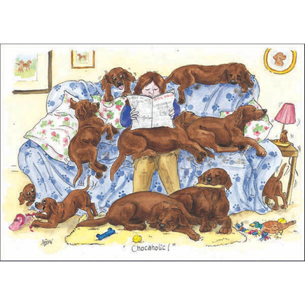 A person relaxes with a newspaper as chocolate-colored dogs play around in this Alisons Animals Funny Dog Card Chocoholicâ€”a delightful, blank-inside card by Alisons Animals, perfect for your own greeting.