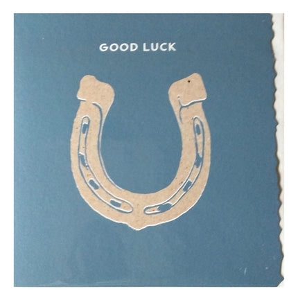 Send good luck wishes with the Equestrian Greeting Card Good Luck Horseshoe by Deckled Edge Ltd—a blue card featuring a tan horseshoe and GOOD LUCK in white, perfect for horse lovers. Blank inside and boasts deckled edges.