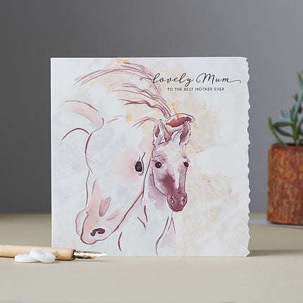 The Deckled Edge Lovely Mum Horse Blank Greeting Card With Envelope by Deckled Edge Ltd features watercolor horses and Lovely Mum to the best mother ever, with a pencil, erasers, and small potted plant in the background.