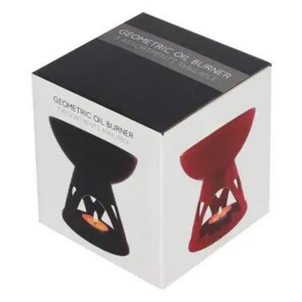 A white box displays the Something Different Wholesale Red Scented Wax Warmer Oil Burner with a modern geometric design and black and red colors. Shown in use with a lit candle, it includes a free melt bar—ideal for warming wax melts.