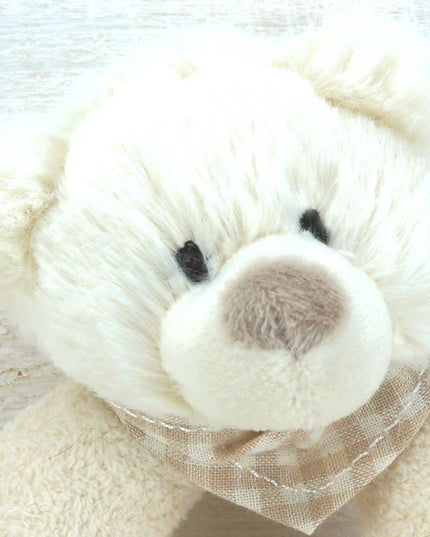 close up of a cream plush rattle with a cute bears head 