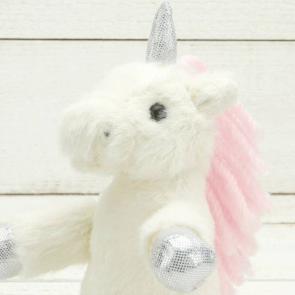 A close up of the head of a cream plush unicorn with sparkly silver hooves and unicorn horn and a pink mane.
