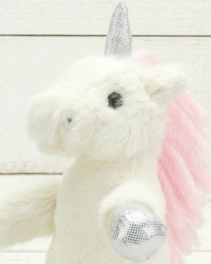 A close up of the head of a cream plush unicorn with sparkly silver hooves and unicorn horn and a pink mane.