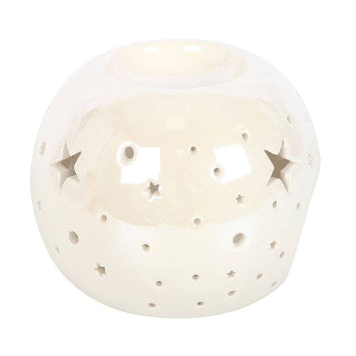 the side of a white spherical wax warmer with stars cut out and and irridescent finish