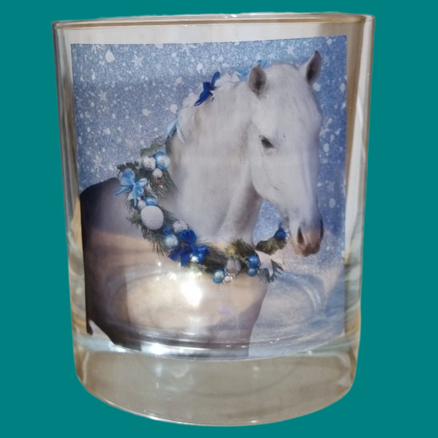 an empty scented candle glass container with a grey horse wearing a festive garland on his neck