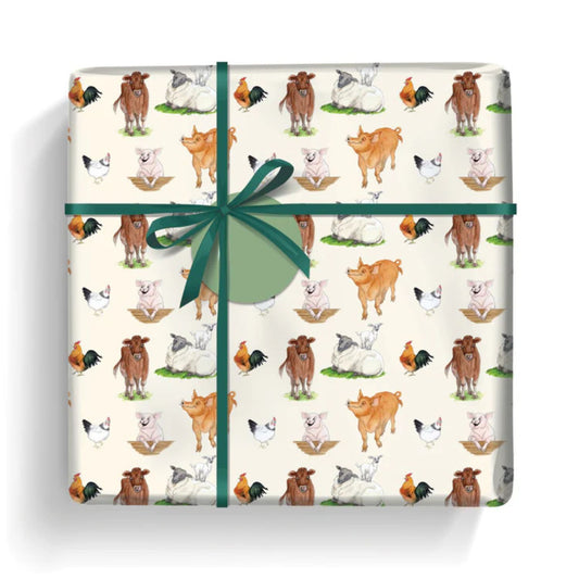 a gift wrapped in paper featuring a range of charming farm animals including cows, pigs, sheep and chickens on a cream background with a round green gift label