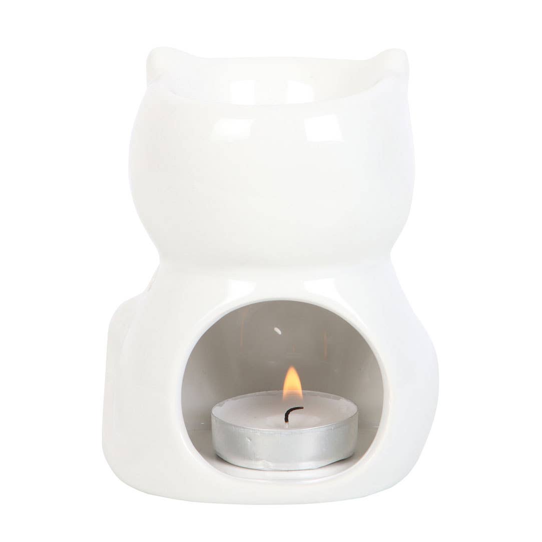 the back view of a shiny ceramic cat oil burner with a lit tealight in place