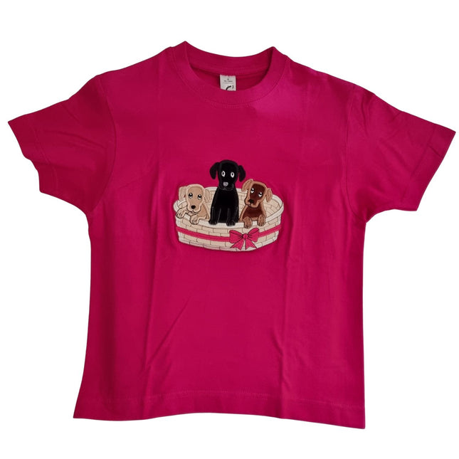 The British Country Collection Dog T Shirt, featuring an embroidered basket of three adorable puppiesâ€”beige, black, and brown with a pink bowâ€”makes a charming choice for children.