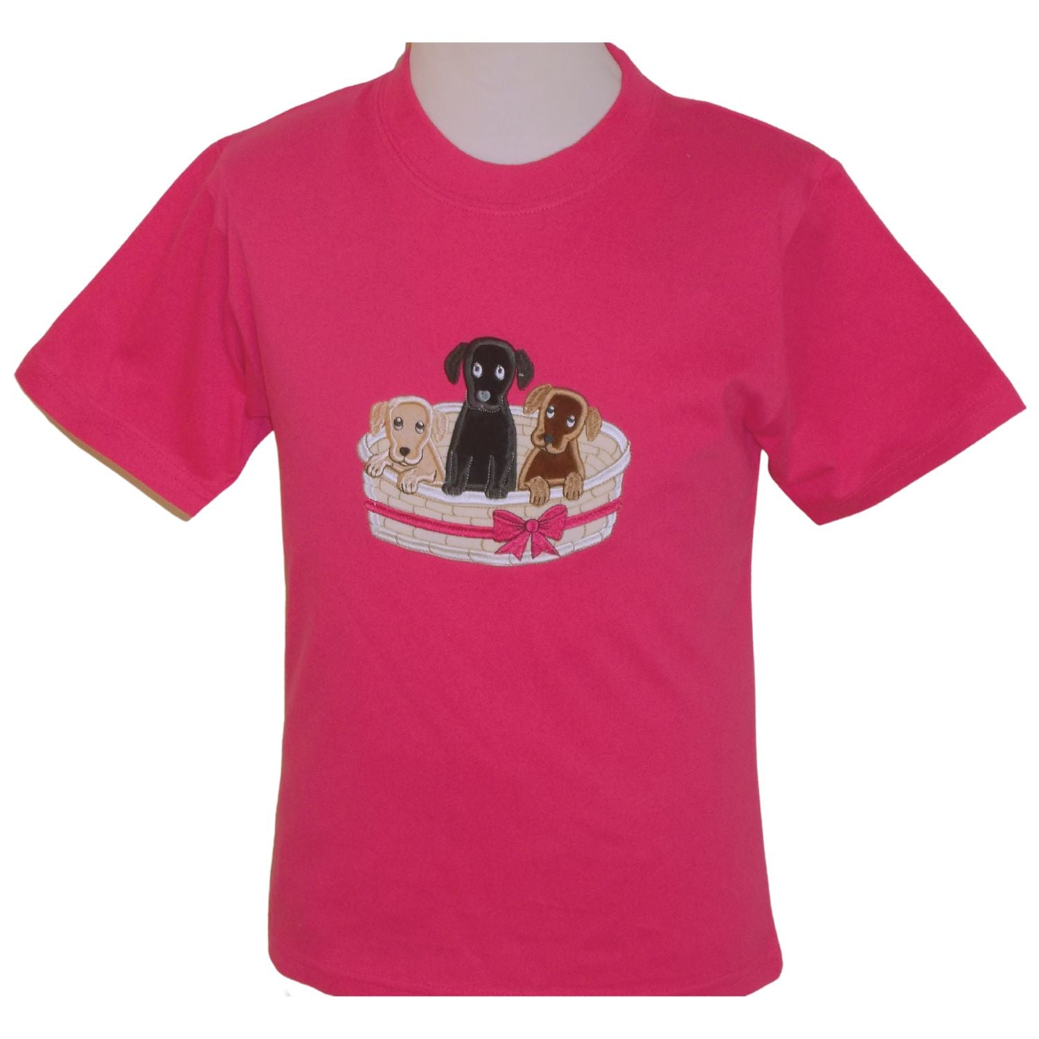 pink short sleeved round neck t shirt with an embroidered basket containing one black, one brown and one cream puppy