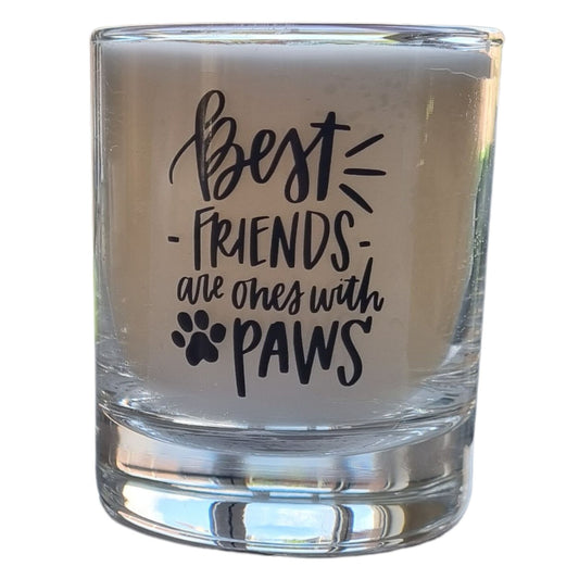 A candle In a glass container with Best Friends Have Paws phrase on the front