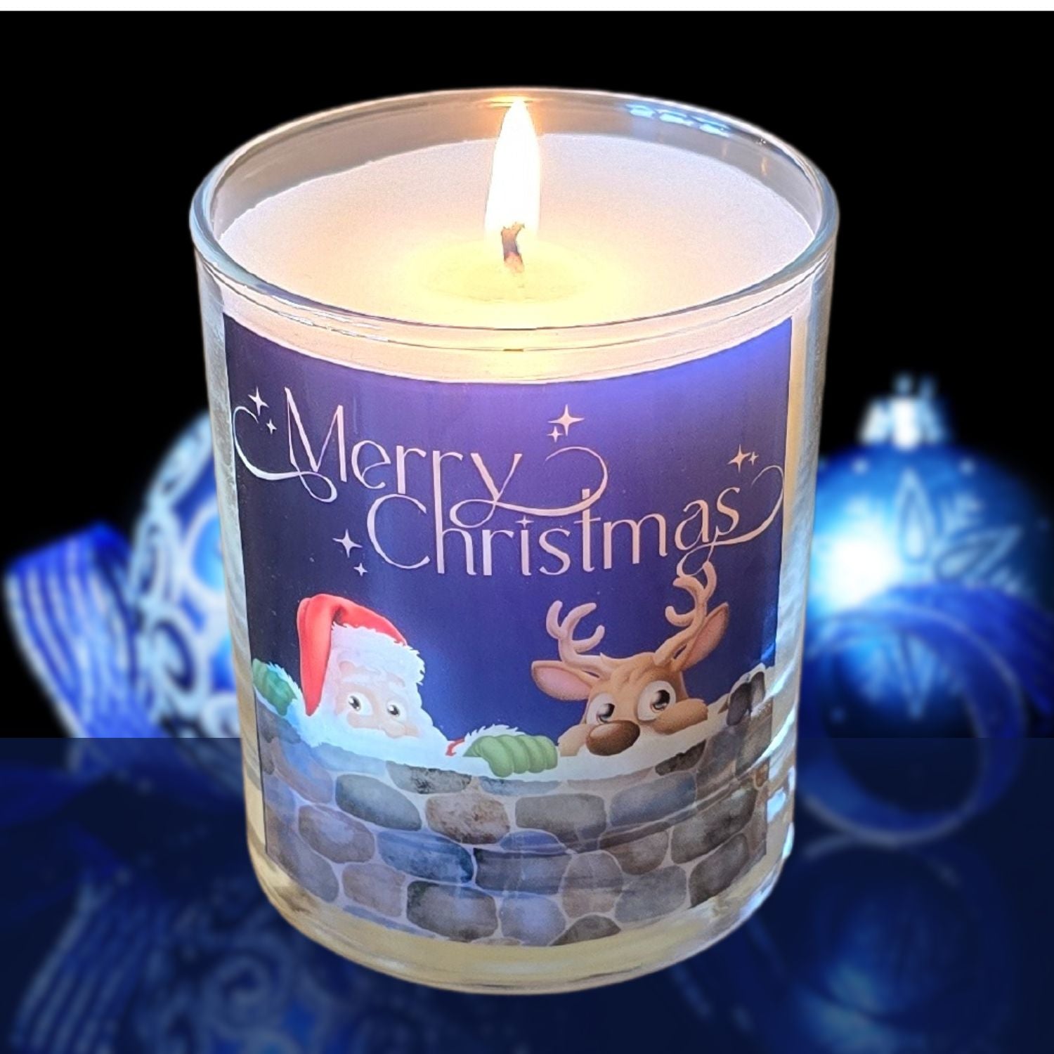 A lit Christmas scented candles with a charming Merry Christmas design featuring Father Christmas and a reindeer peeping over a wall. 