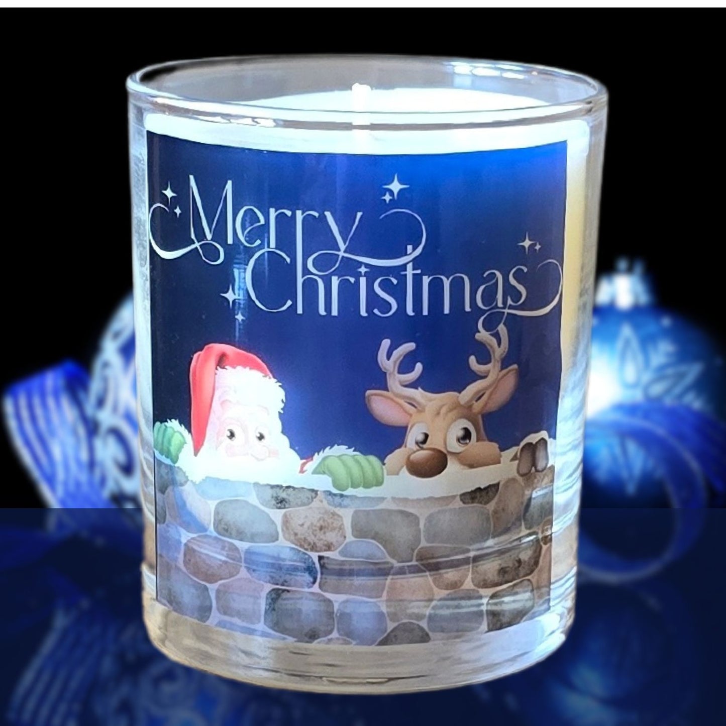 A Christmas scented candles with a charming Merry Christmas design featuring Father Christmas and a reindeer peeping over a wall