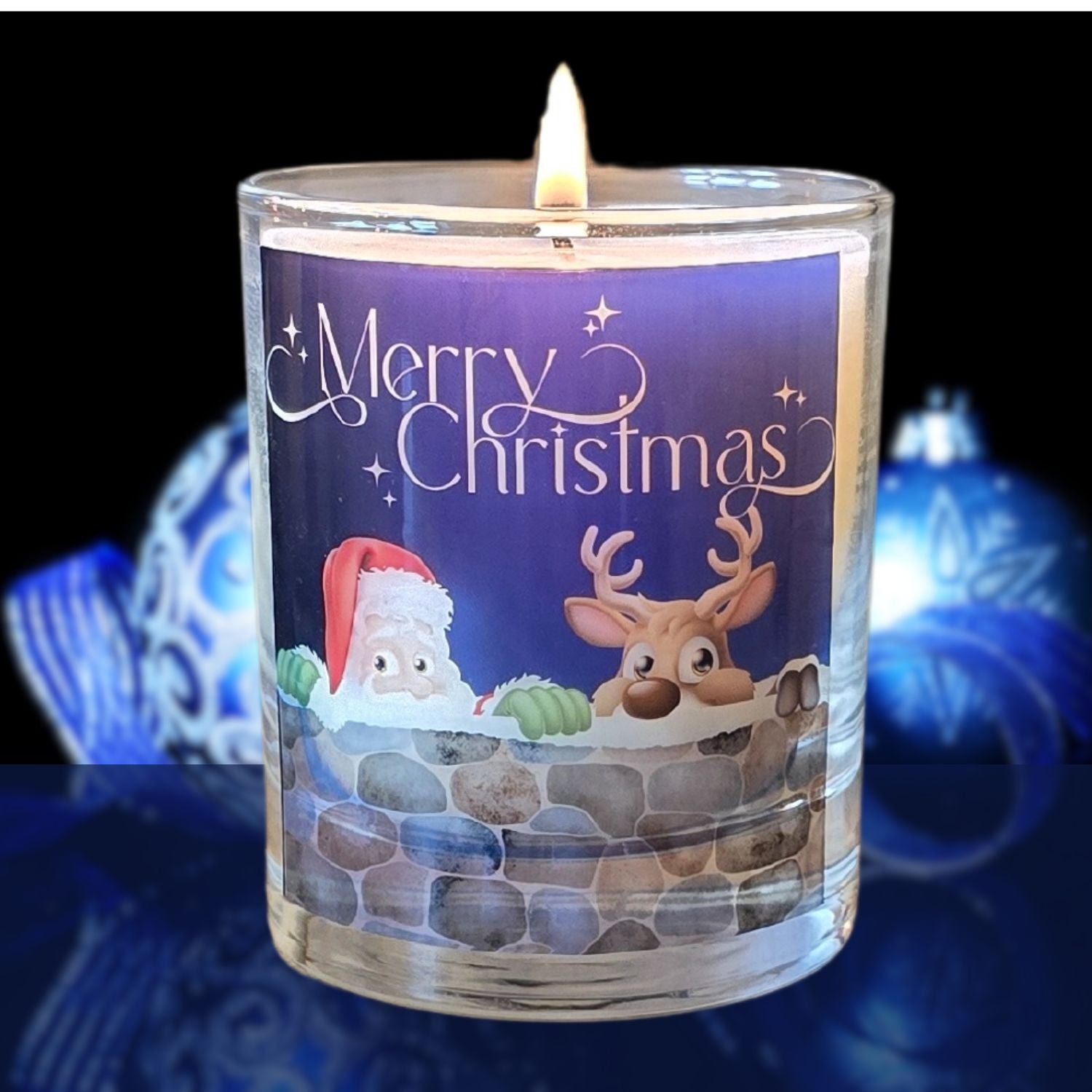 A lit Christmas scented candles with a charming Merry Christmas design featuring Father Christmas and a reindeer peeping over a wall