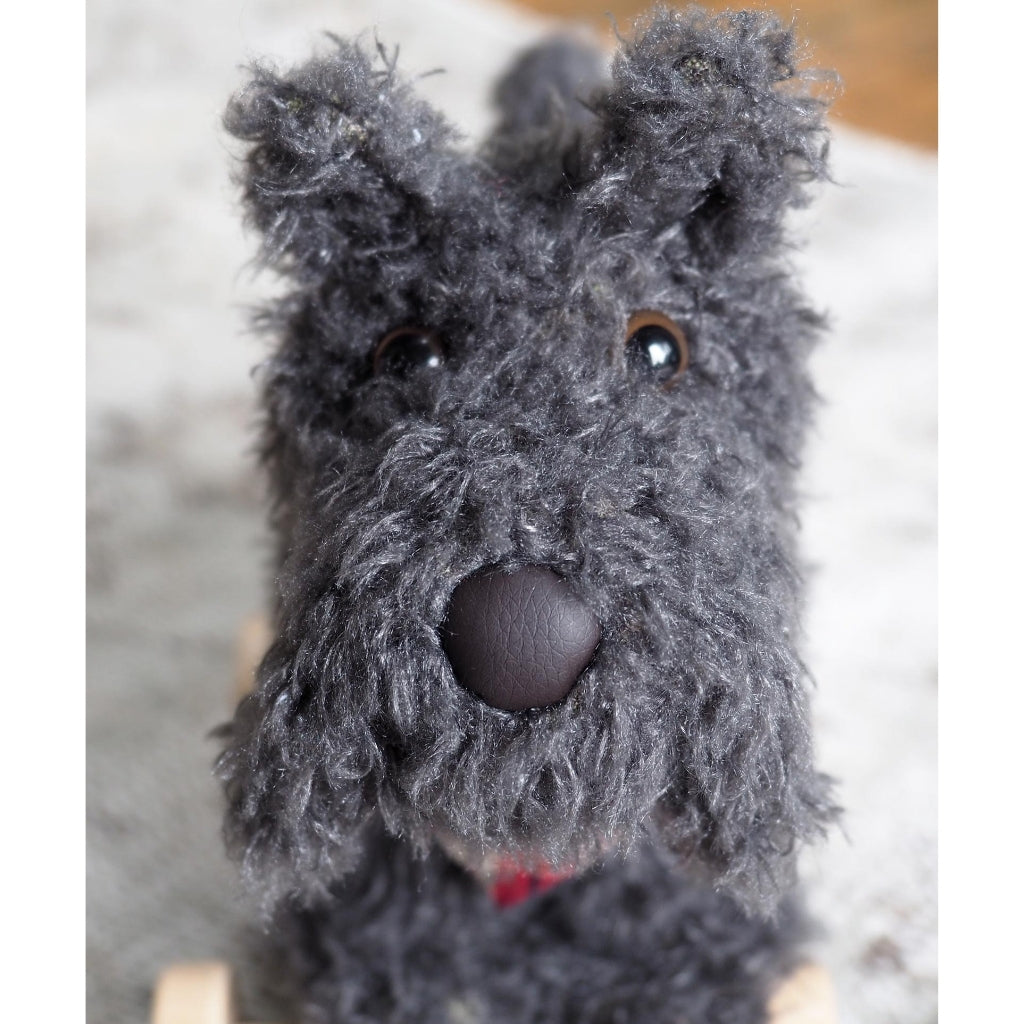 close up of the face of a soft toy scottie dog with grey fur and a cute nose