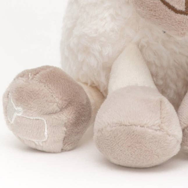 close up of the beige hooves of a sheep soft toy made of very soft white plush fur with beige hooves