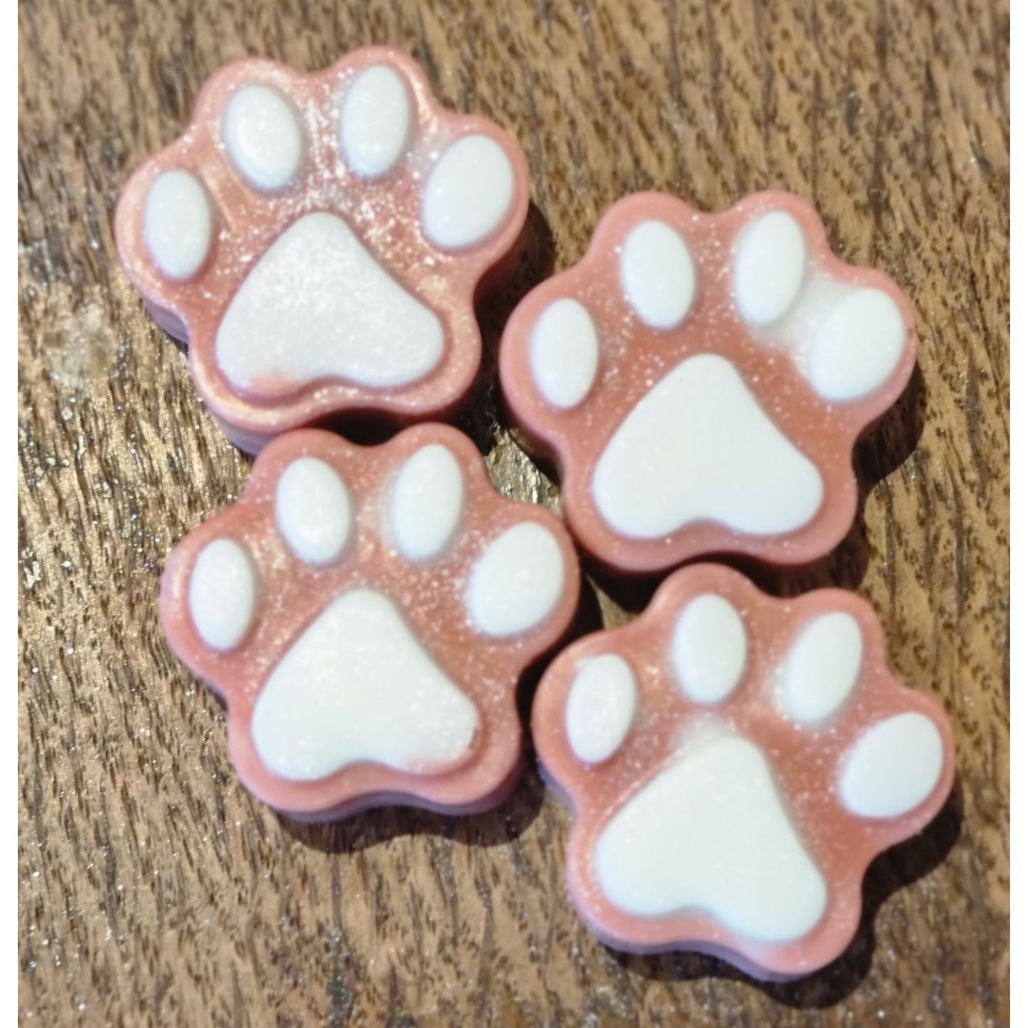 four brown paw shaped wax melts with white paw pads 