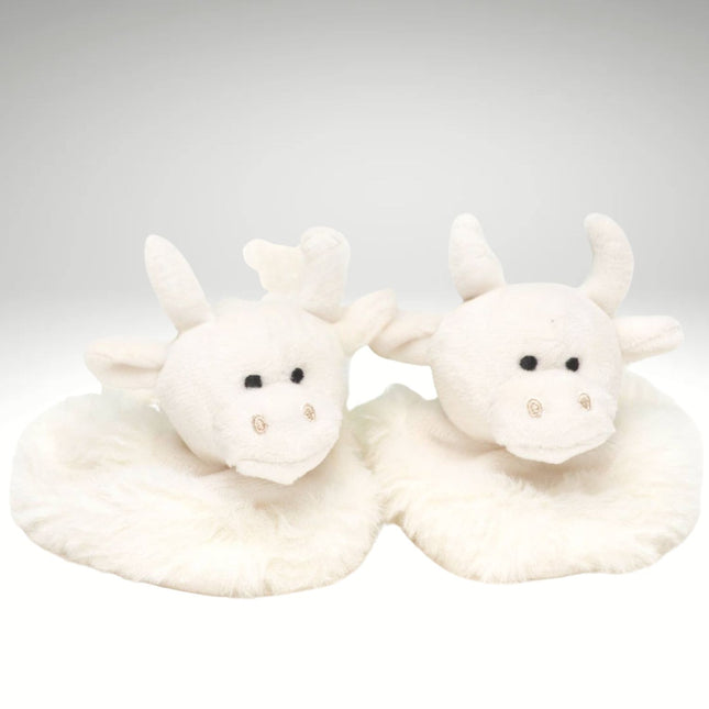 a pair of fluffy cream baby boots featuring cute highland cow heads 