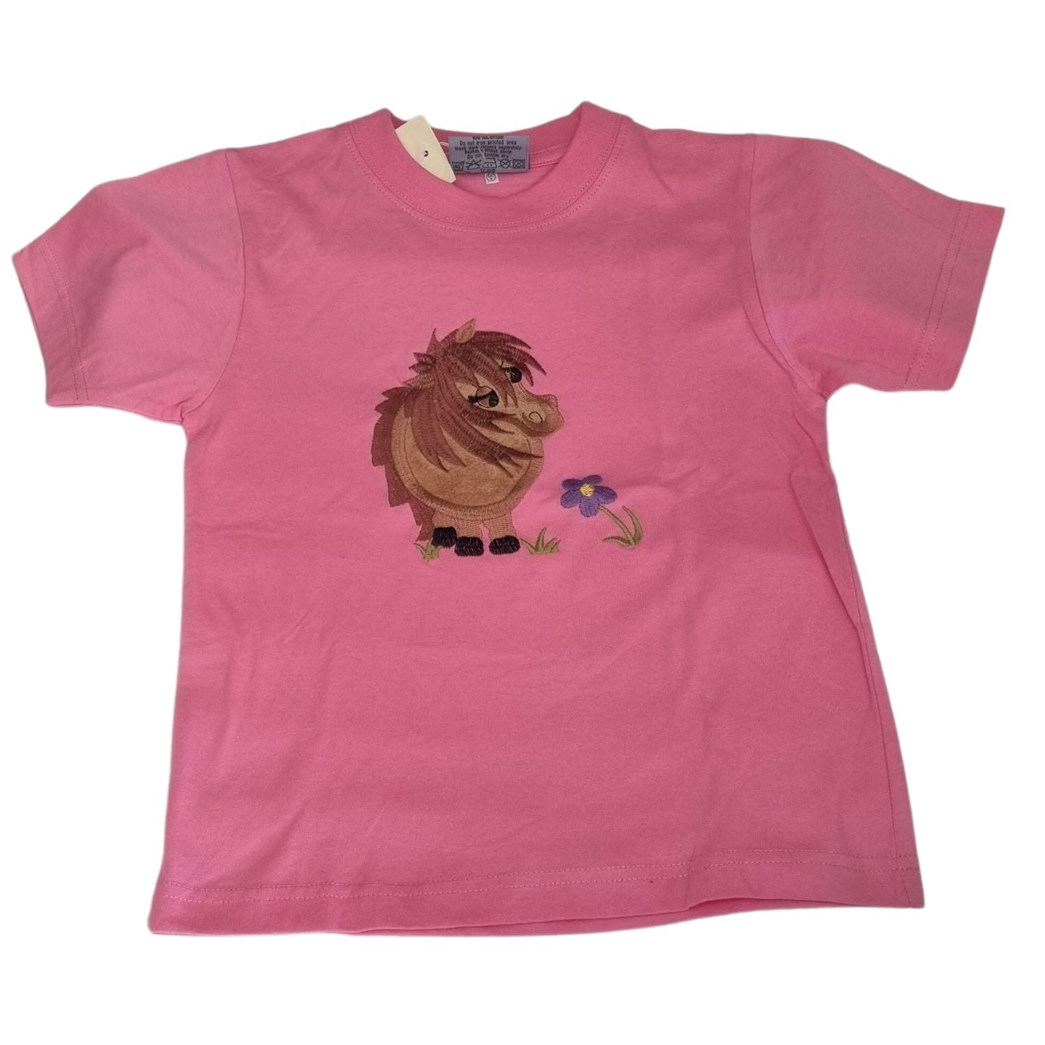The Ramblers Embroidered Horse T Shirt Childrens Pink Cuddly Pony is a kidsâ€™ short-sleeved 100% cotton tee, featuring charming embroidery of a brown cartoon horse with a purple flower on the front.