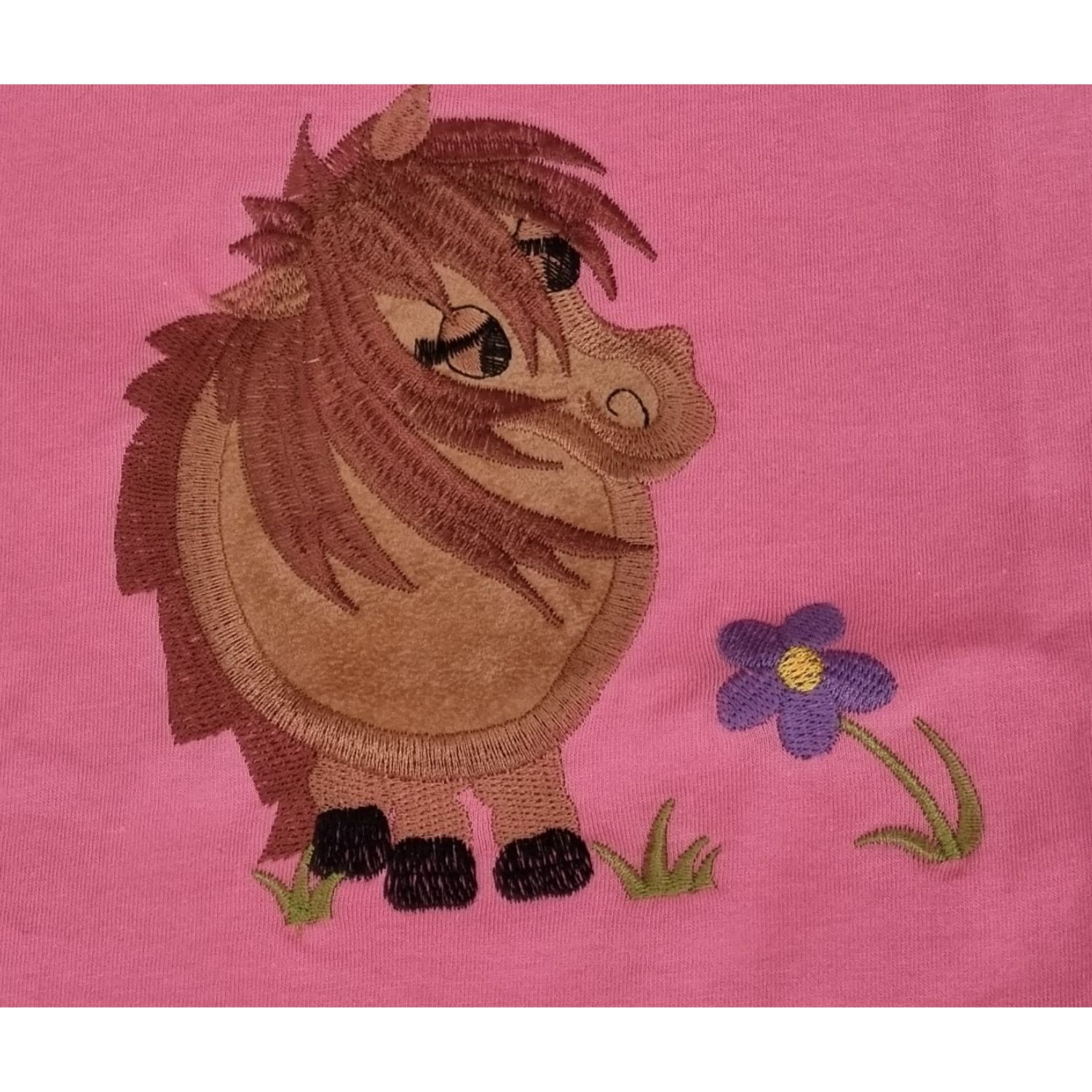 The Ramblers Embroidered Horse T Shirt features a cute brown cartoon pony with a big belly on pink 100% cottonâ€”perfect for kids who love whimsical and cuddly designs.