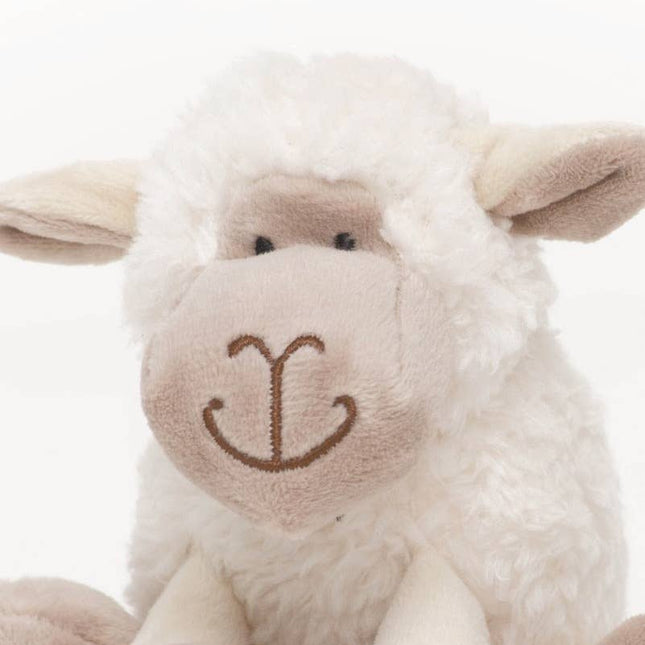close up of the face of a sheep soft toy made of very soft white plush fur and beige plush face and inner ear in 