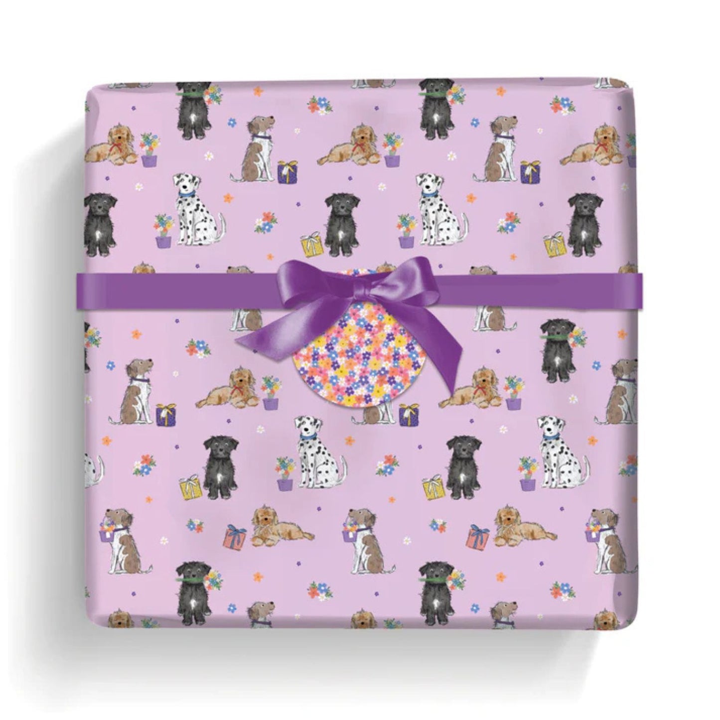 a gift wrapped with cute greeting paper featuring dogs with flowers and presents on a soft pink background completed with a floral gift tag