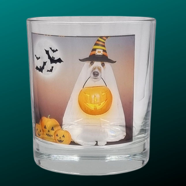 A scented Halloween candle tealight holder featuring a spooky dog in a sheet dressed as a ghost with a trick or treat pumpkin bowl