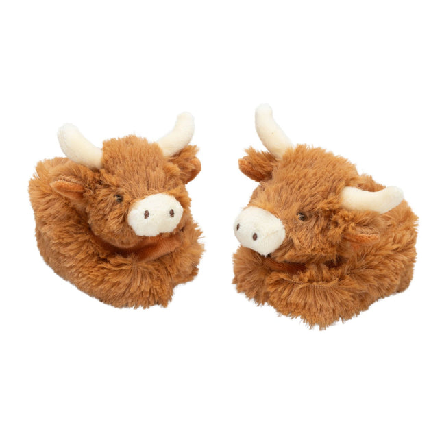 a pair of fluffy brown baby boots featuring cute highland cow heads with cream nose and horns