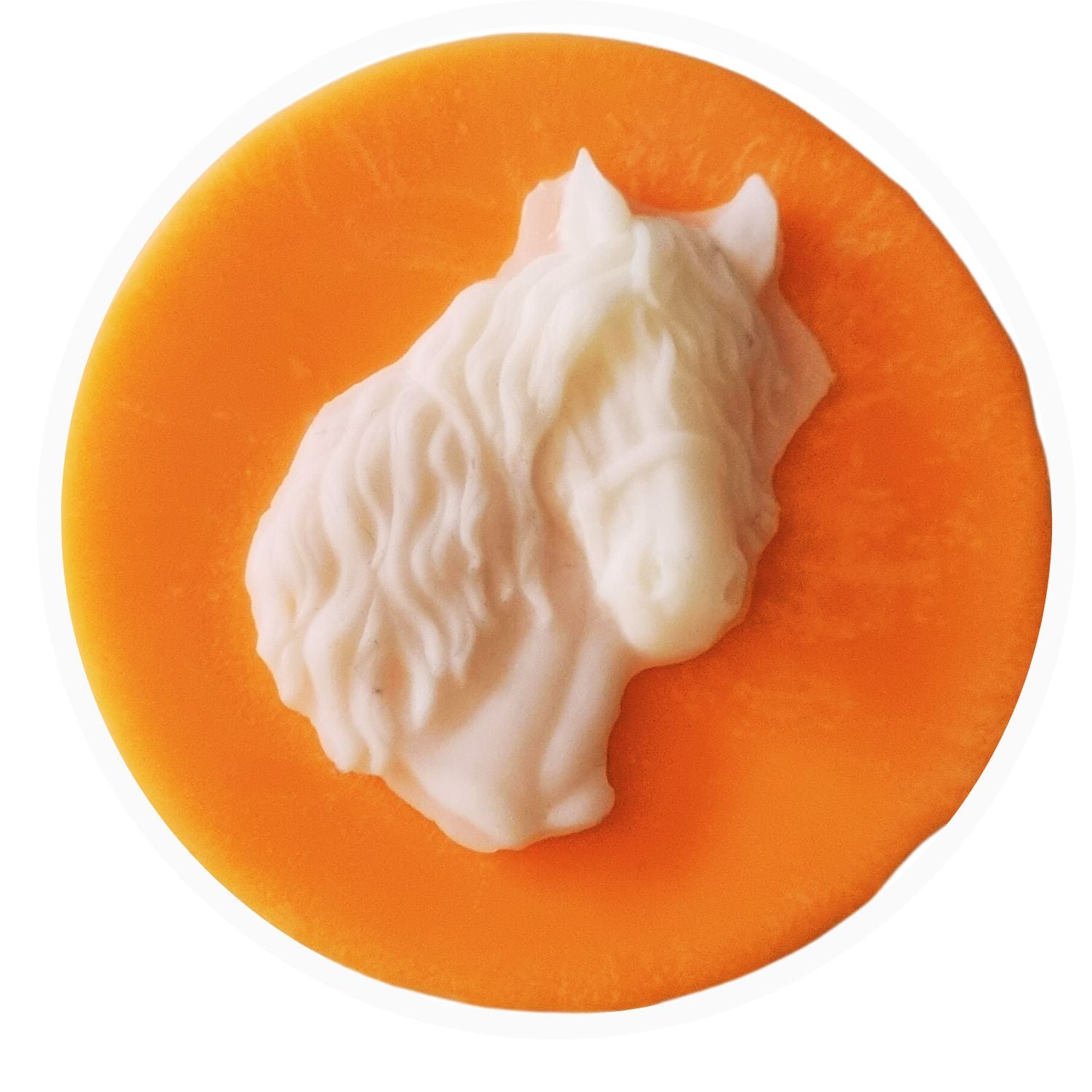 An orange coloured disc shaped wax melt with a white wax horses head with a flowing mane and forelock.