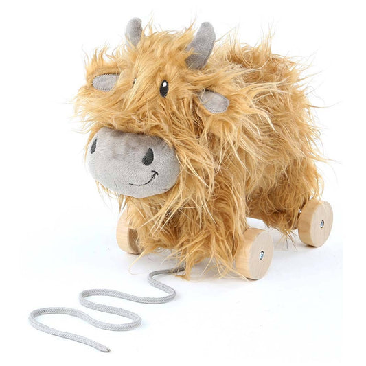 a cute highland cow stuffed toy with golden fur on wooden wheels