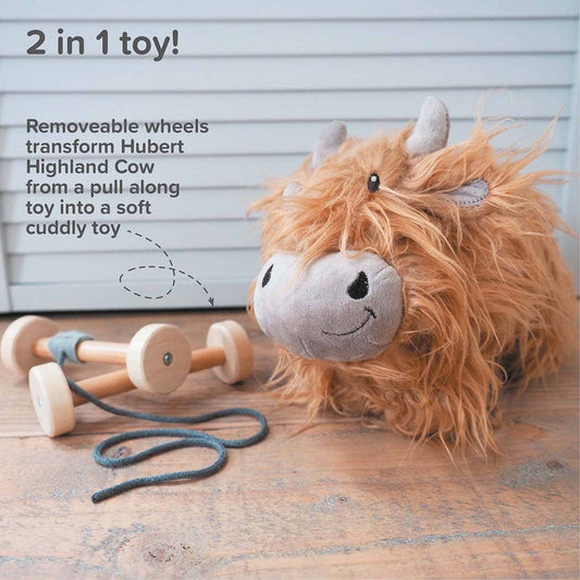 a cute highland cow stuffed toy with golden fur next to a set of detachable wheels wooden wheels