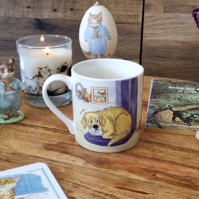 The Alisons Animals Cat and Dog Mug I Do Own The Place, featuring charming artwork, sits on a wooden table with cat-themed decor like a candle, figurine, painted egg, and illustrated cards. Gift boxed for the perfect present.
