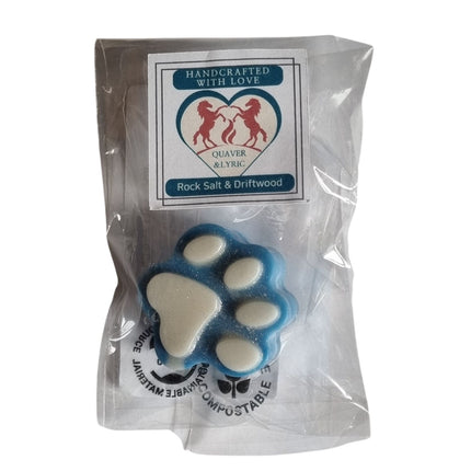 A blue and white paw-shaped soap is in clear packaging with a label reading â€œHighly Scented Soy Wax Melt Paw Shaped Various Fragrances, Quaver&Lyric,â€ featuring two red horses in a heartâ€”ideal with handmade fragrance oils.