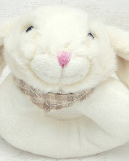 close up of a circular cream plush baby rattle with a cute floppy eared bunny head
