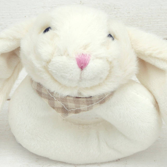 close up of a circular cream plush baby rattle with a cute floppy eared bunny head