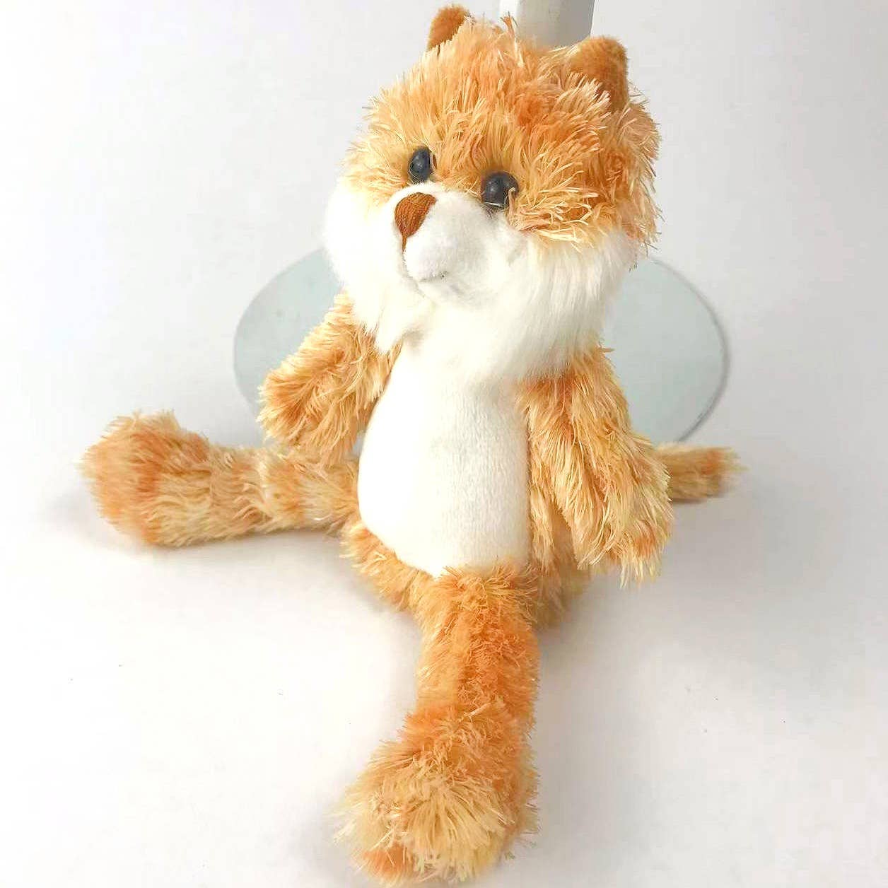 a ginger cat soft toy made of orange plush fur and a white tummy and chin