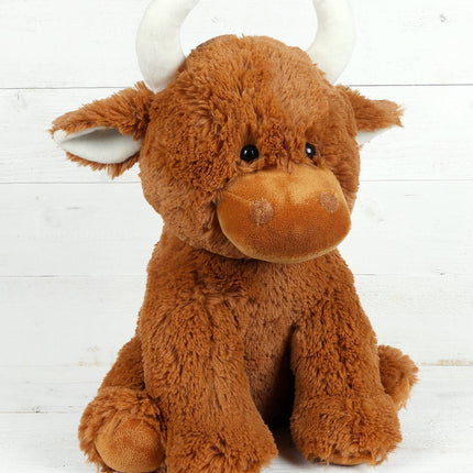 The Large Highland Cow Teddy Jomanda Plush Baby Soft Toy by Jomanda Soft Toys & Accessories sits upright with white horns against a white wooden background. This adorable plush is machine washable for easy care.