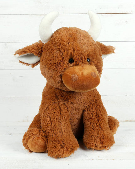 The Large Highland Cow Teddy Jomanda Plush Baby Soft Toy by Jomanda Soft Toys & Accessories sits upright with white horns against a white wooden background. This adorable plush is machine washable for easy care.