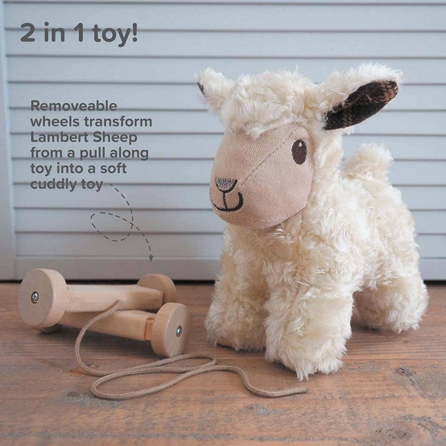 The Little Bird Told Me UK Pull Along Toy Sheep Lambert is a plush, smiling sheep with detachable wooden wheels and a pull string, offering tactile fun as both a cuddly friend and pull-along toy. Text reads 2 in 1 toy! and highlights its features.