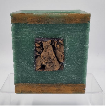 The Quaver&Lyric Plant Pot Holder Square Green Wax features brown borders, a textured brown center accent, and an aged gold decoration for an antique effect, displayed on a clear stand—an elegant storage solution.