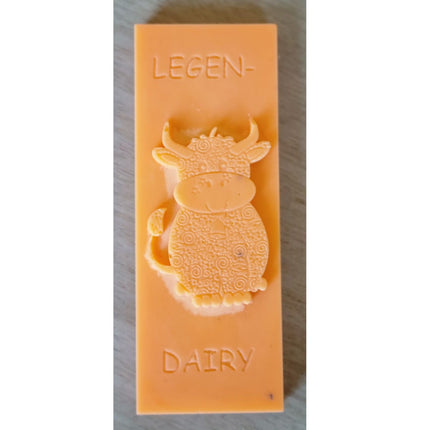 an orange Wax Melt bar with highland cow and writing legen....dairy