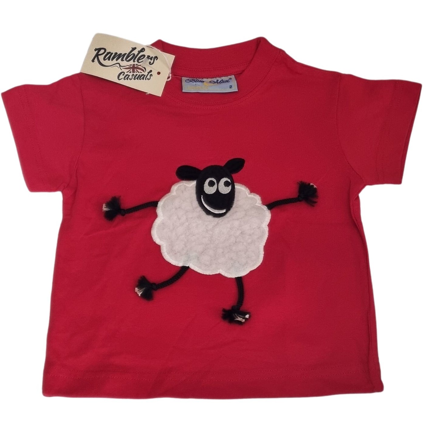 The Ramblers Sheep Embroidered T Shirt Red With Applique Dangly Leg Lamb features a smiling cartoon sheep with black limbs and a fluffy white body. Made from 100% cotton, this toddler tee is machine washable and has a Ramblers tag on the collar.